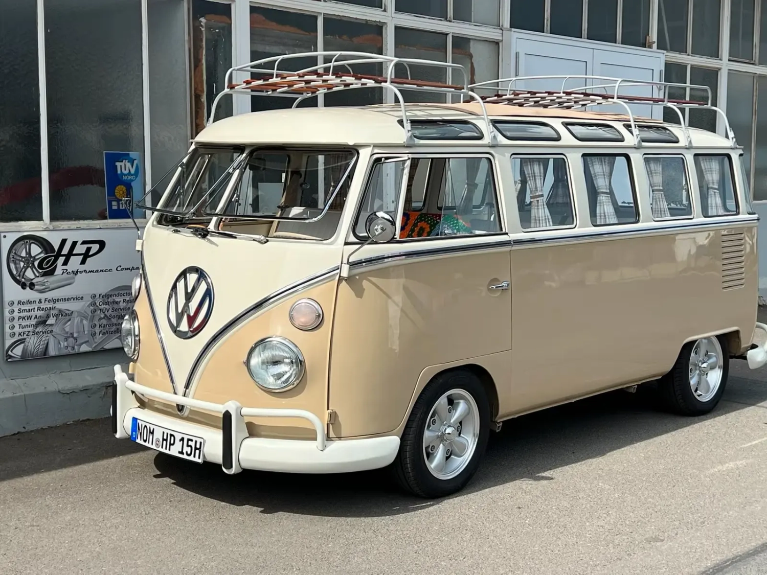 VW T1 Samba Bulli vor der Werkstatt, dahinter das Schild von HP Performance Company